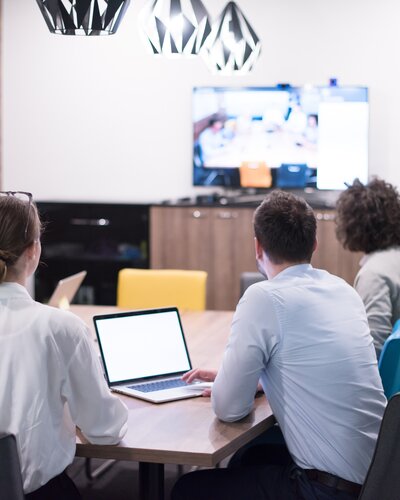 People sit in a hybrid meeting. | © Shutterstock