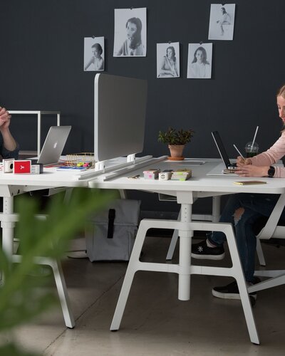 Two people work at their desks.