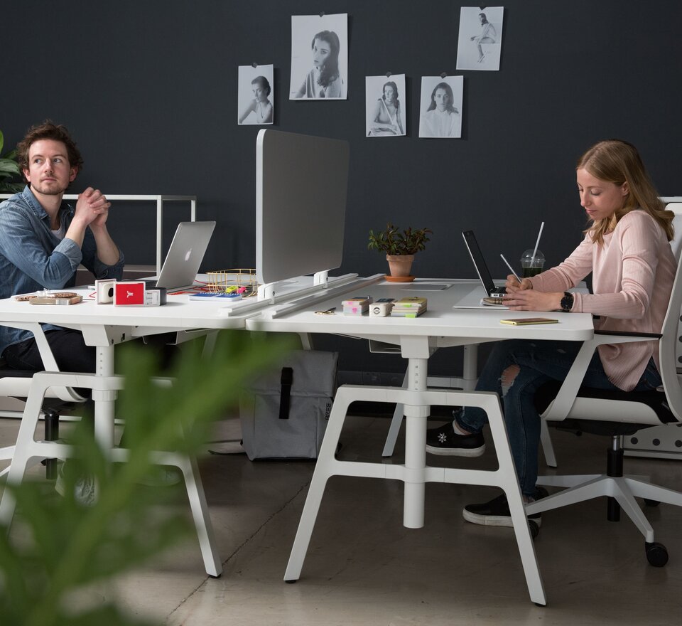 Two people work at their desks.