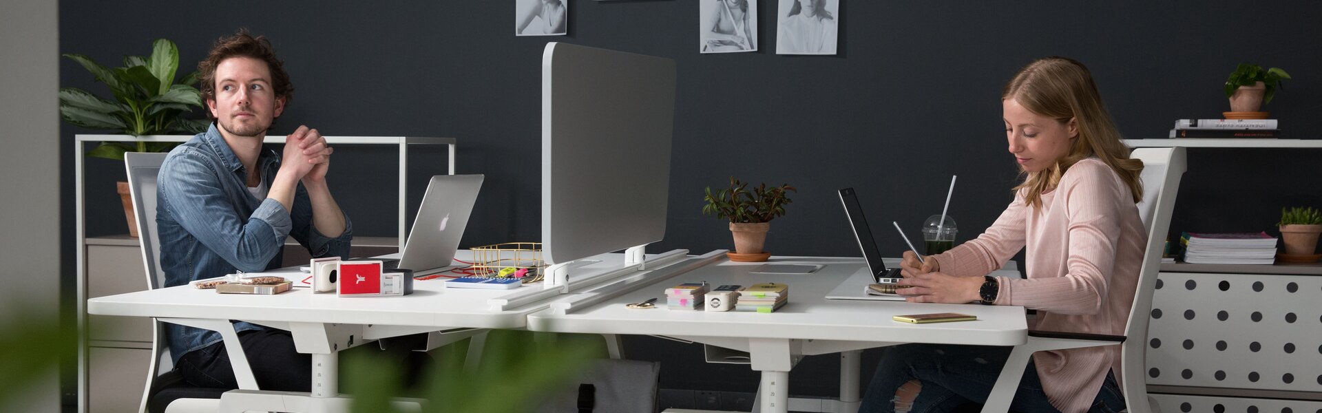 Two people work at their desks.