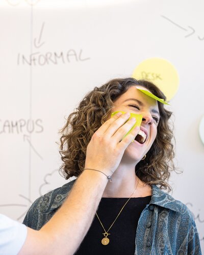 Zwei Personen die Spaß mit Post-its haben.