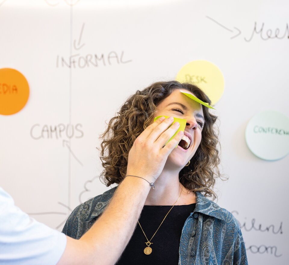 Zwei Personen die Spaß mit Post-its haben.