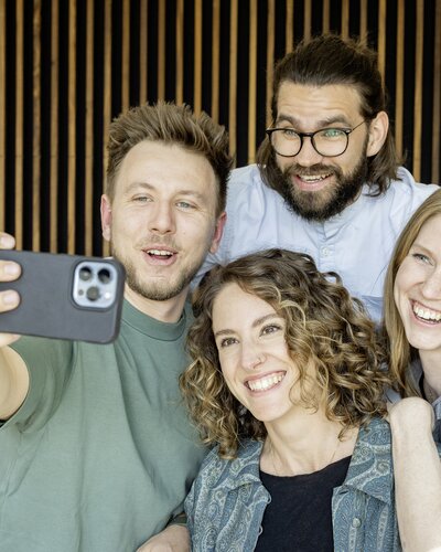 Four people taking a selfie.