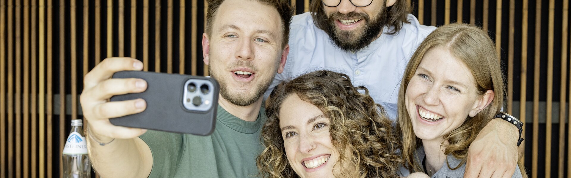 Four people taking a selfie.