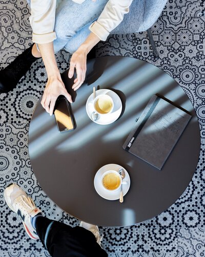 Two people sitting at a bistro table.