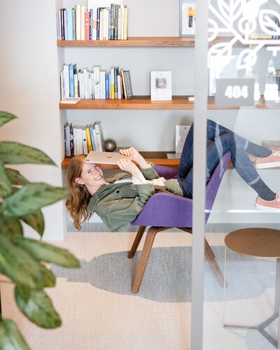 Person is sitting on a purple lounge chair upside down.