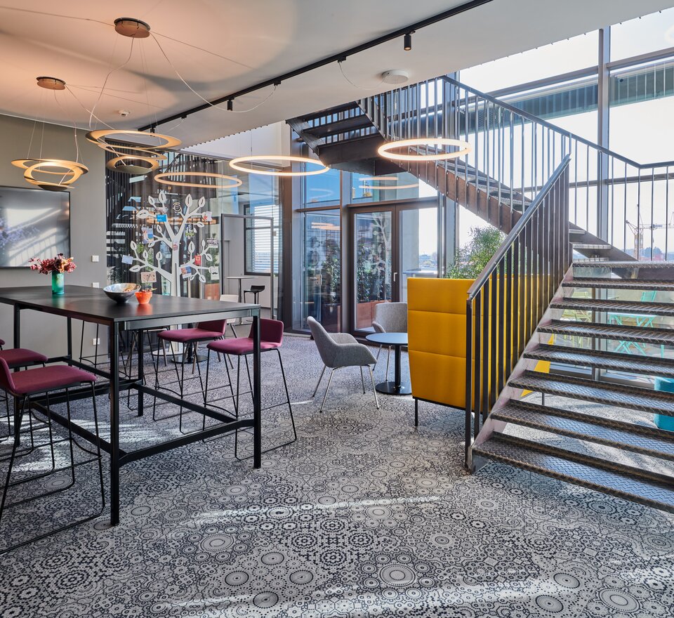 Cafebereich mit Treppe im Coworkingbüro. | © raumpixel.at